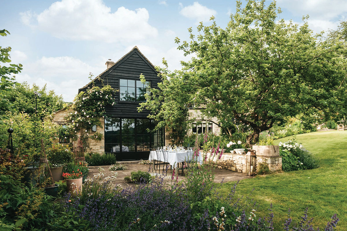 Flower-filled country garden and outdoor dining area at The Knapp in the Cotswolds