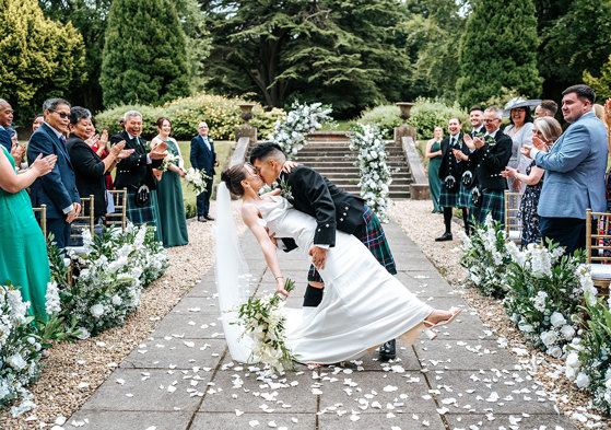 bride and groom dip kiss after outdoor wedding ceremony at mar hall
