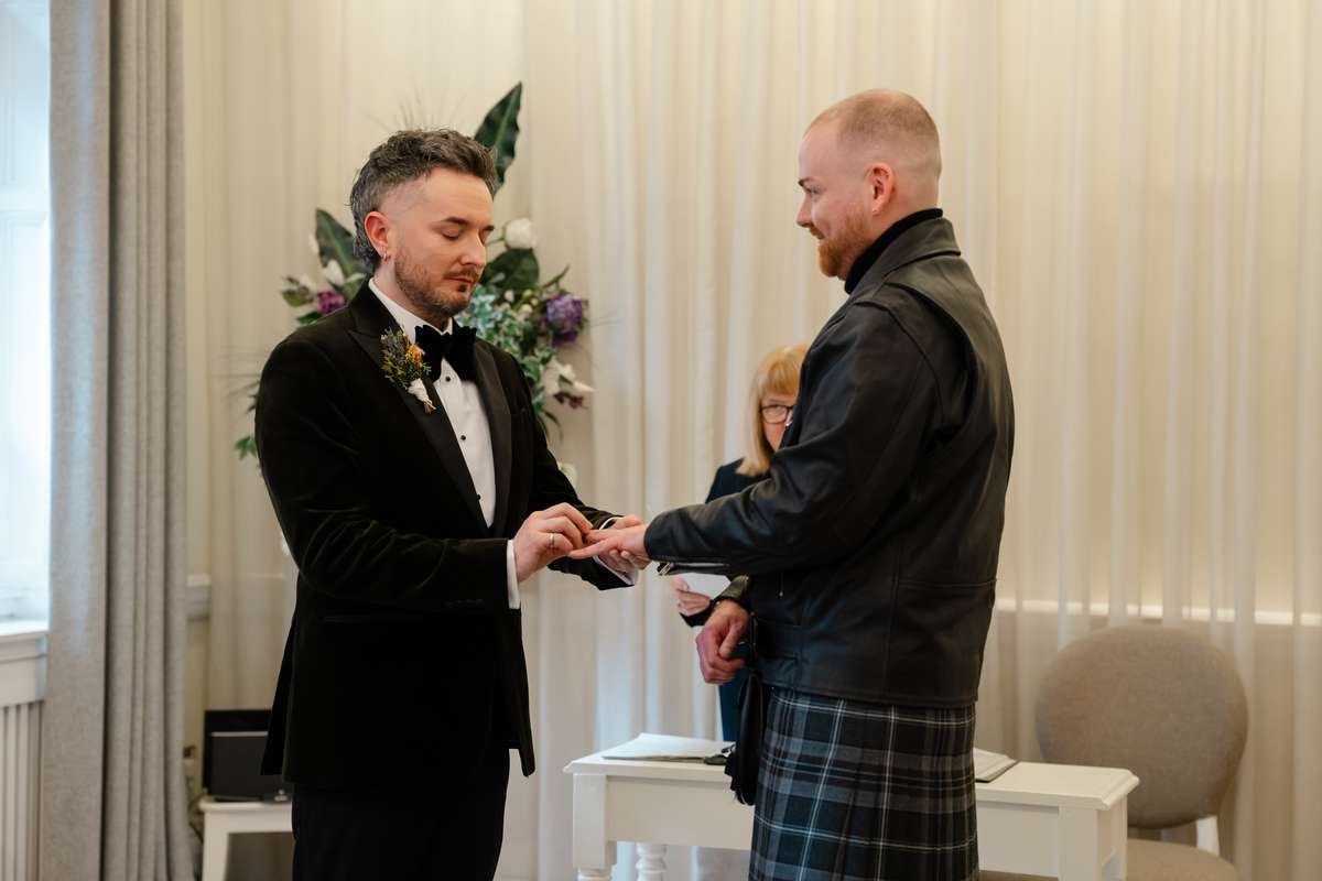 Couple exchanging wedding rings during their ceremony at 23 Montrose Street in Glasgow