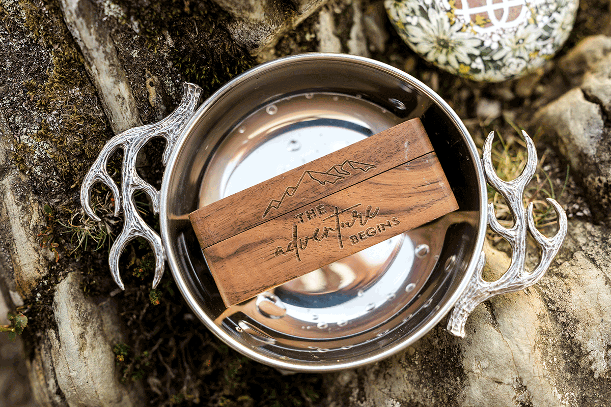 Decorated quaich and engraved keepsake displayed on rocks during a Scottish mountain elopement celebration