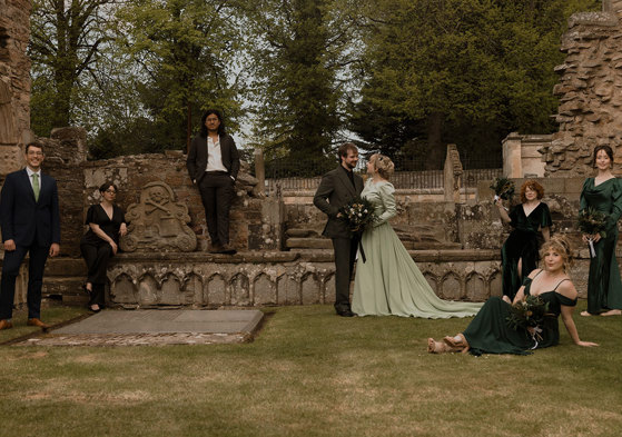 a wedding group posing in the graveyard at Elgin Cathedral