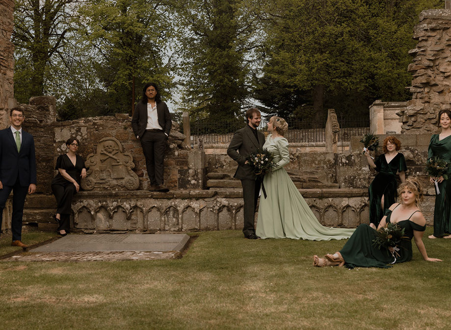 a wedding group posing in the graveyard at Elgin Cathedral