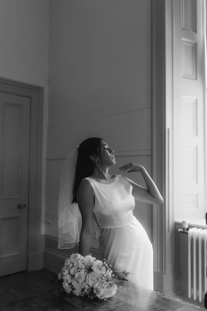 black and white picture of bride with bouquet at kilmardinny house in bearsden