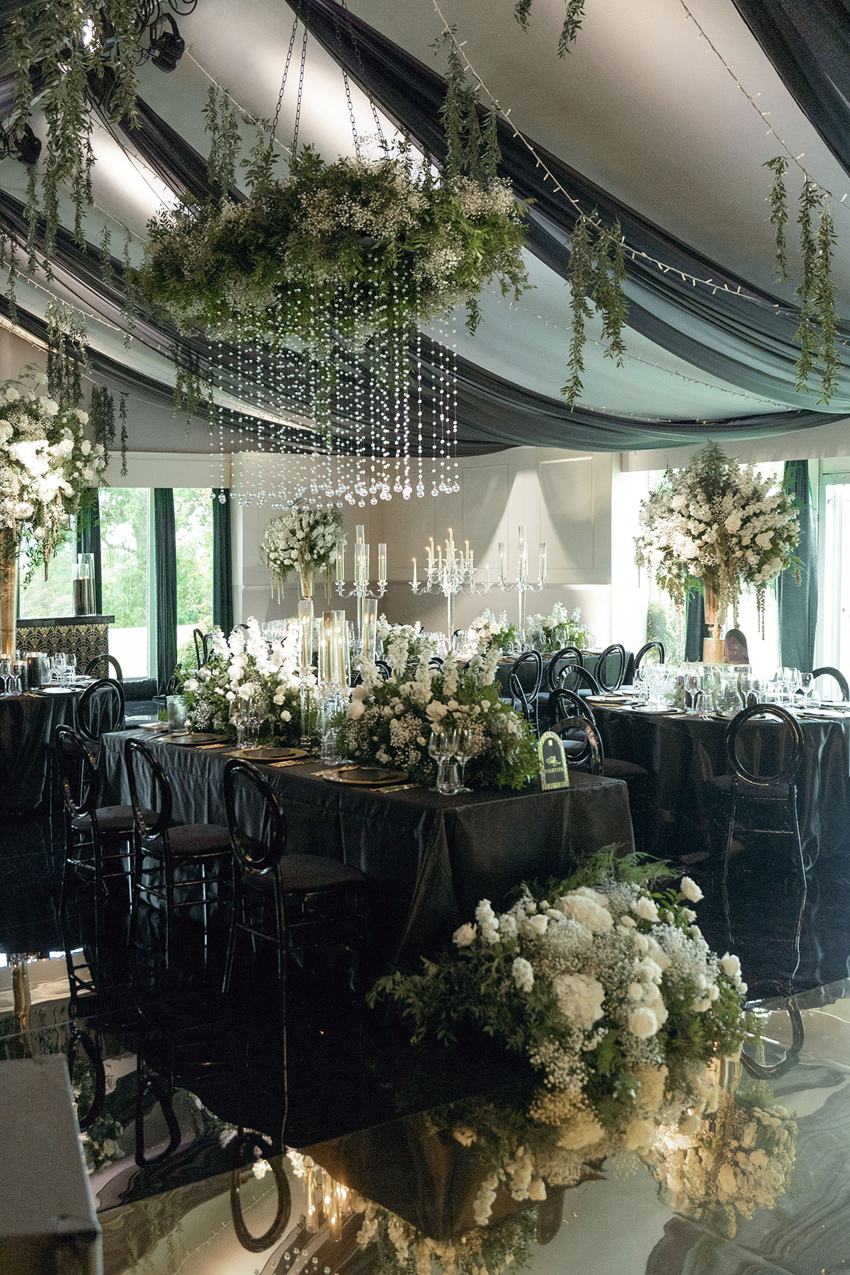 Dundas Castle ballroom set for a destination wedding with black draping, white florals and candlelight décor.
