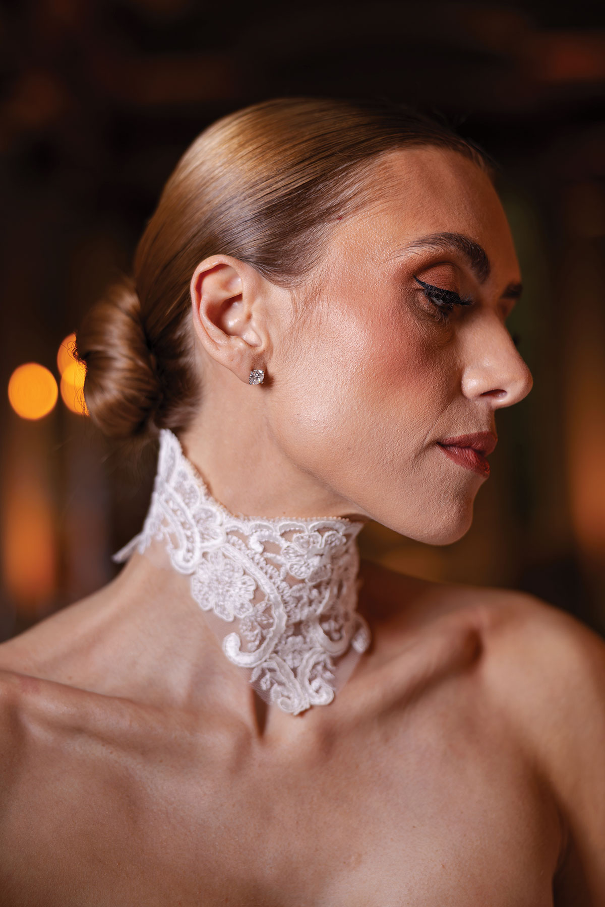 Bridal beauty portrait with sleek bun hairstyle and lace choker necklace