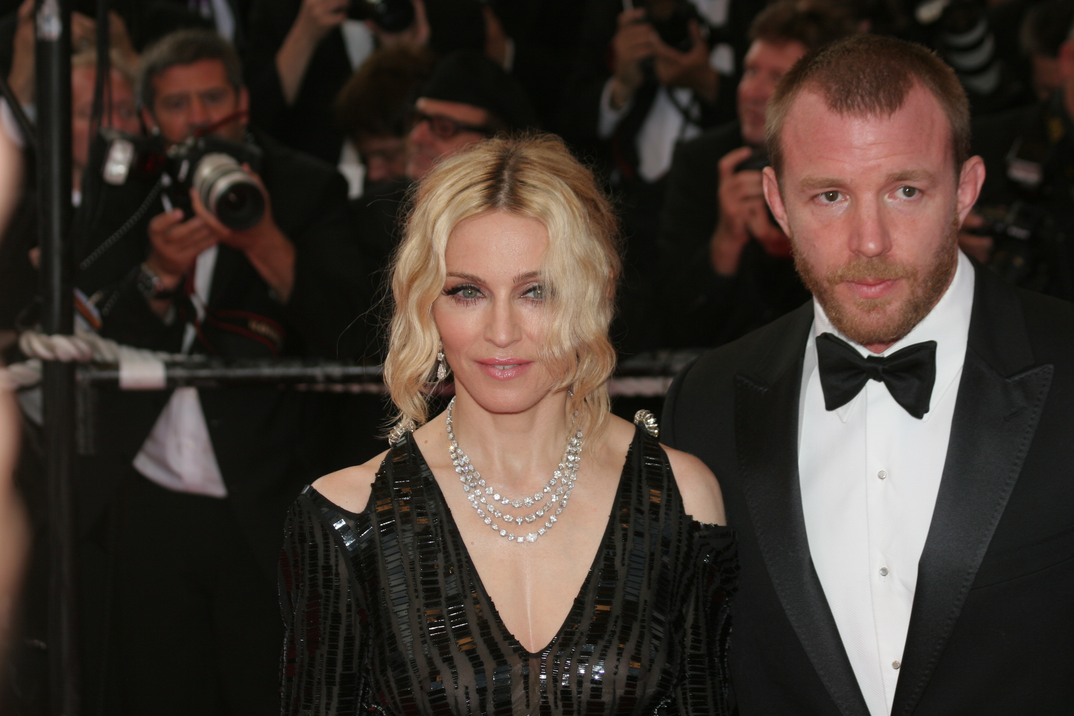 madonna and guy ritchie pose for photograph on red carpet wearing black tie outfits