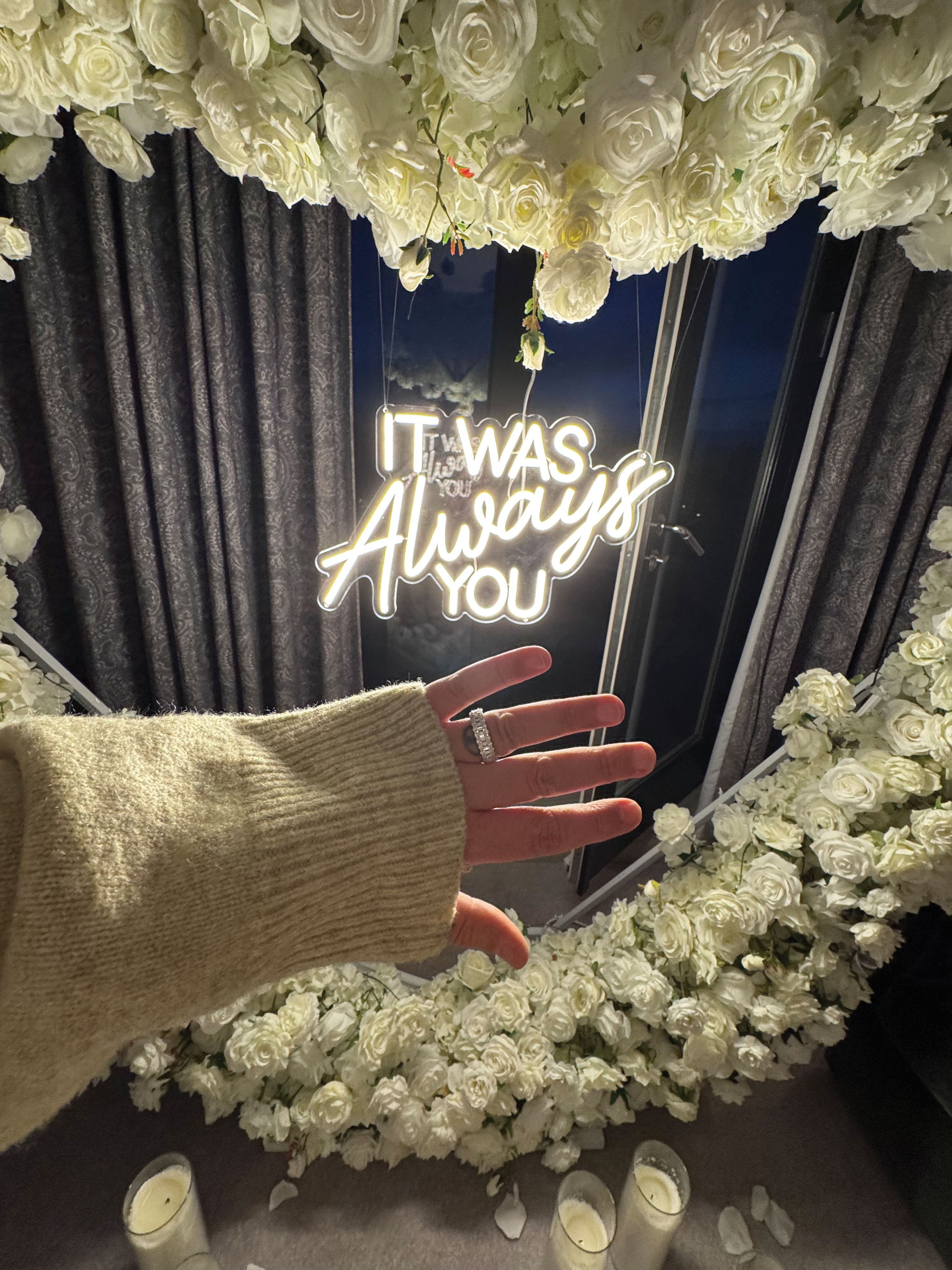 large diamond band engagement ring in front of floral display