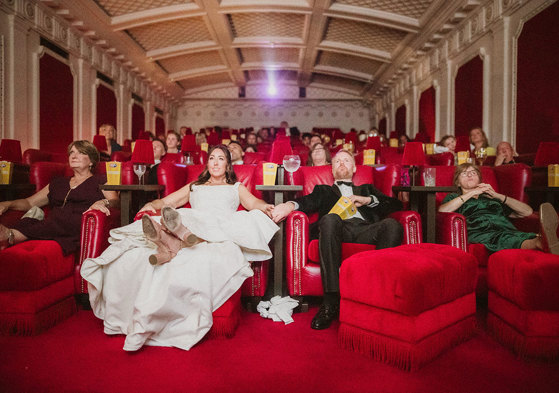 A group of people sitting in chairs in a red cinema theatre at Scotsman Picturehouse