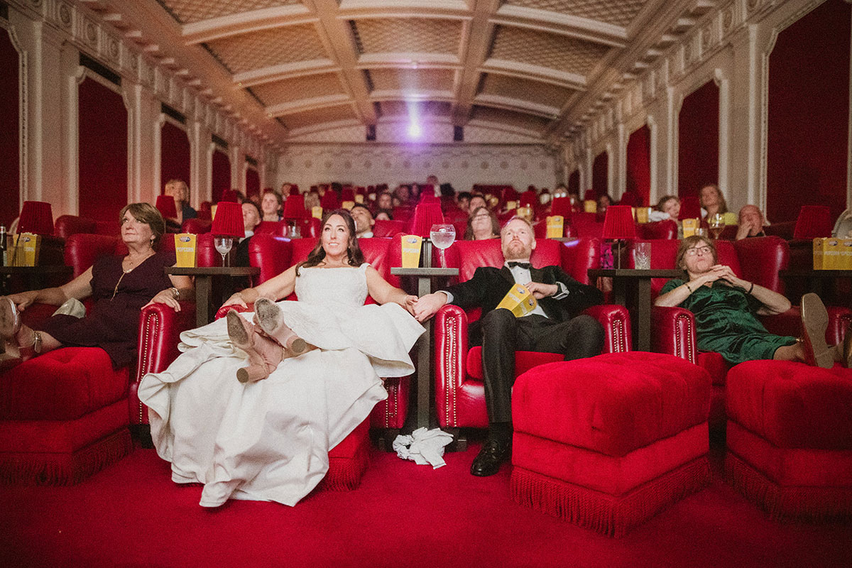 A group of people sitting in chairs in a red cinema theatre at Scotsman Picturehouse