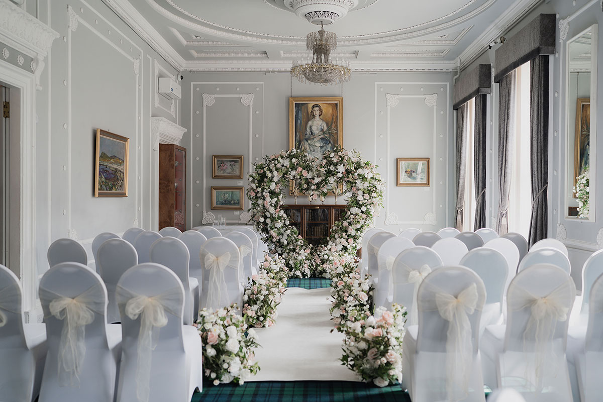 ceremony set up at 1599 in glasgow with white seat covers and pink flowers