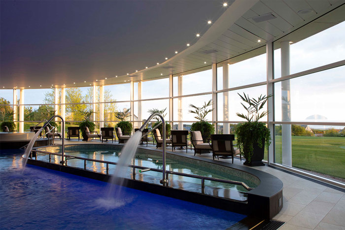 A swimming pool with two shower heads facing into the pool with water flowing from them