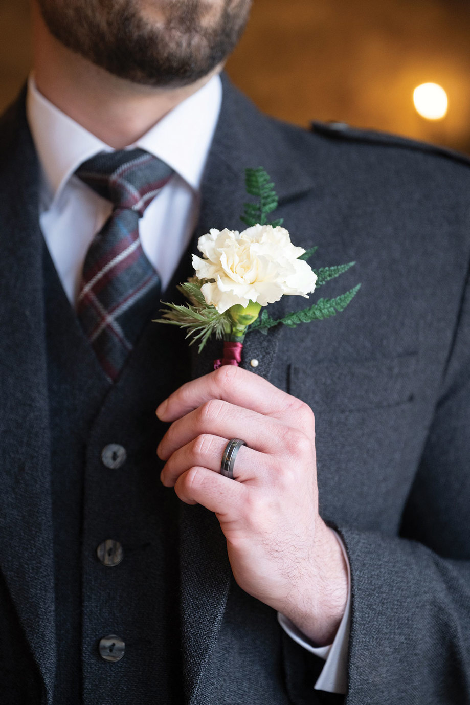 a carnation buttonhole on a grey tweed jacket 