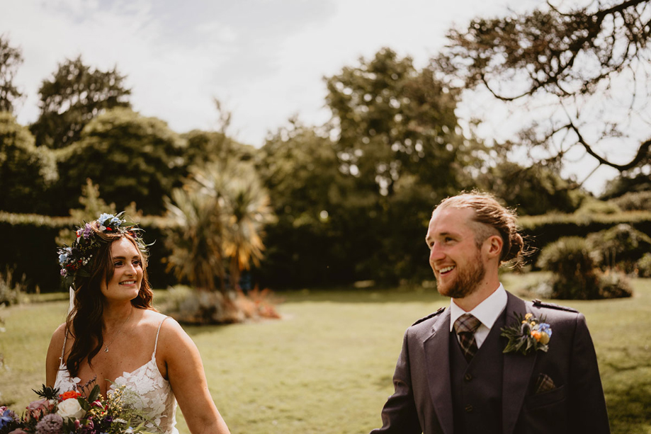 Bride looks at groom in outdoor couple portrait