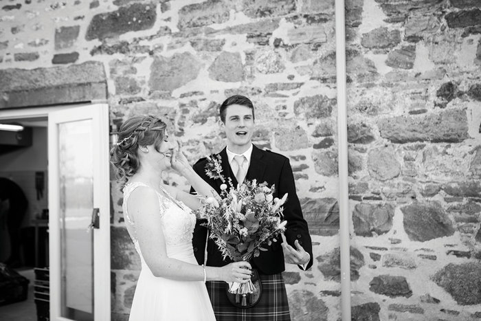 Bride holding her bouquet laughs with her groom following their ceremony
