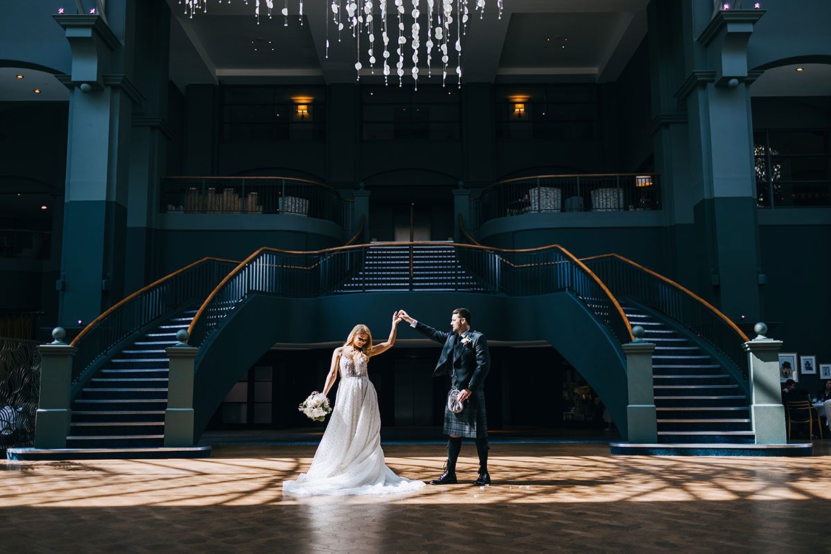 Bride and groom in the atrium at Fairmont St Andrews, a coastal wedding venue in Fife