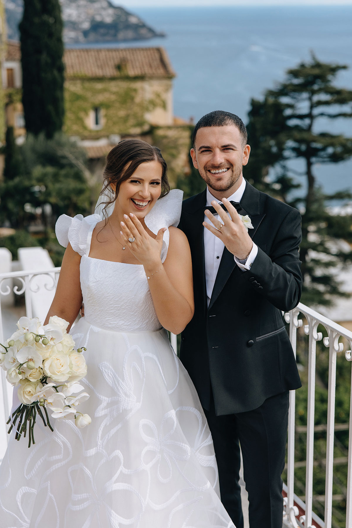 Wedding couple showing their engagement ring and wedding band during a destination wedding by the coast.
