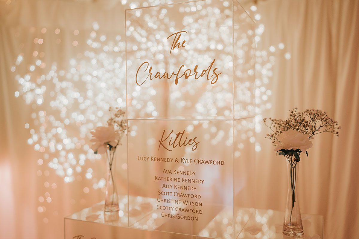 Perspex wedding table plan with gold lettering and soft lighting at Ingliston Country Club
