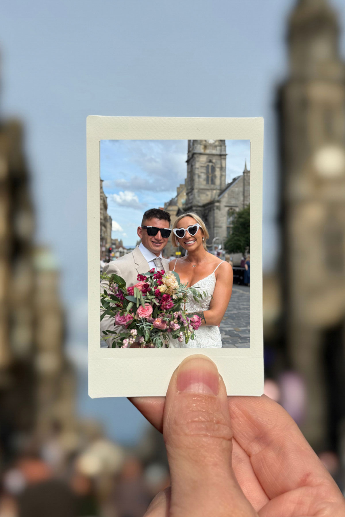 Polaroid-style photo of bride and groom with bouquet on the Royal Mile, Let’s Do It Creative