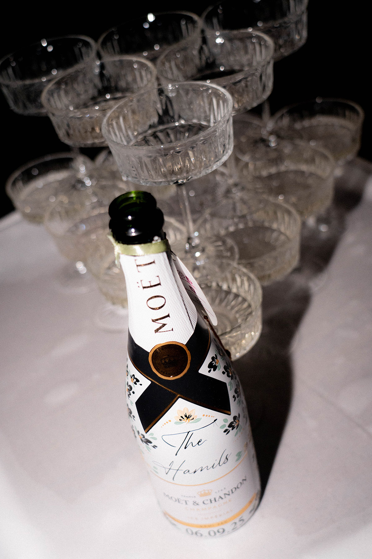 Personalised Moët & Chandon bottle beside stacked coupe glasses at Brisbane House Hotel wedding