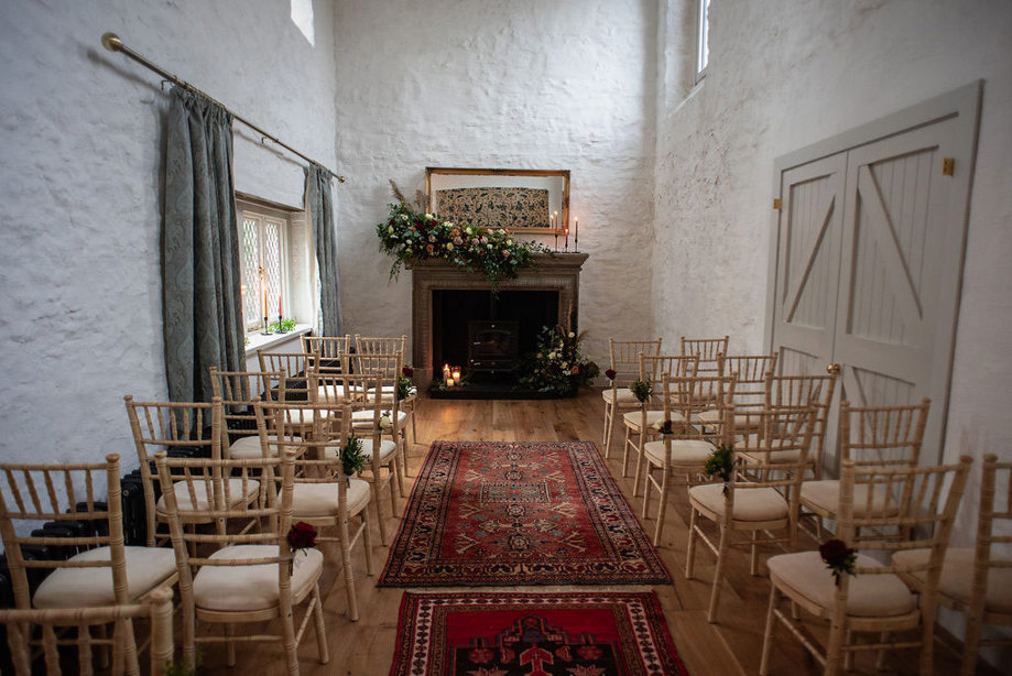 indoor ceremony set up with wooden chairs and red patterned rug at carrick castle