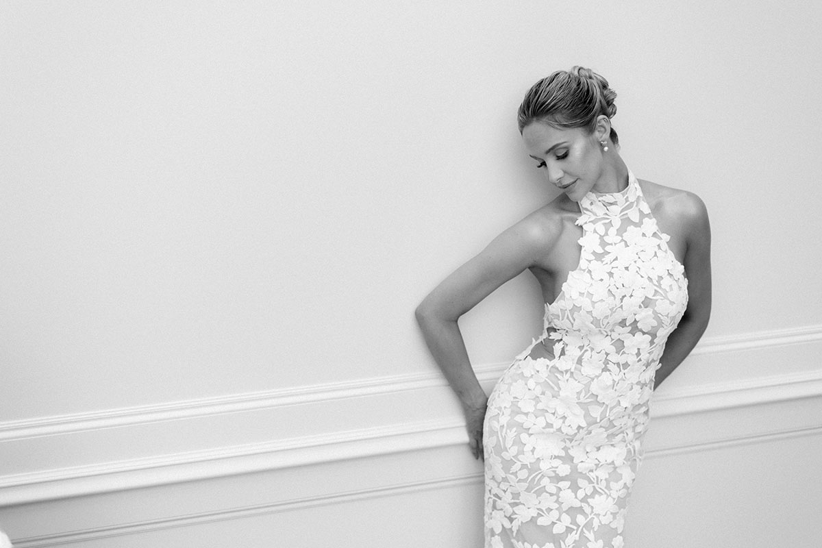 black and white picture of emily shak wearing a high neck lace wedding dress