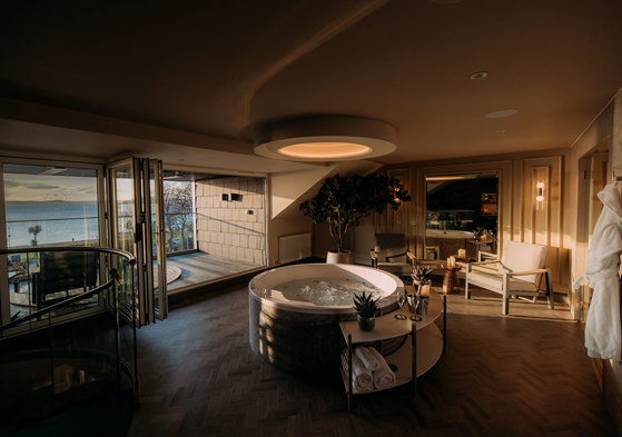 an indoor hot tub with an ocean balcony view