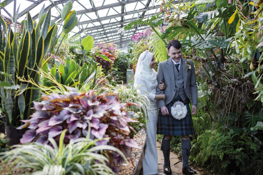 Bride And Groom Walking In The Glasshouse At Inverness Botanic Gardens