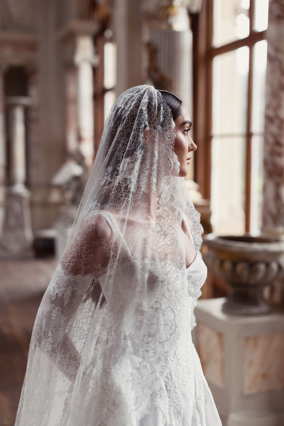 Bridal model wearing a lace veil in the grand upper hall at Gosford House.