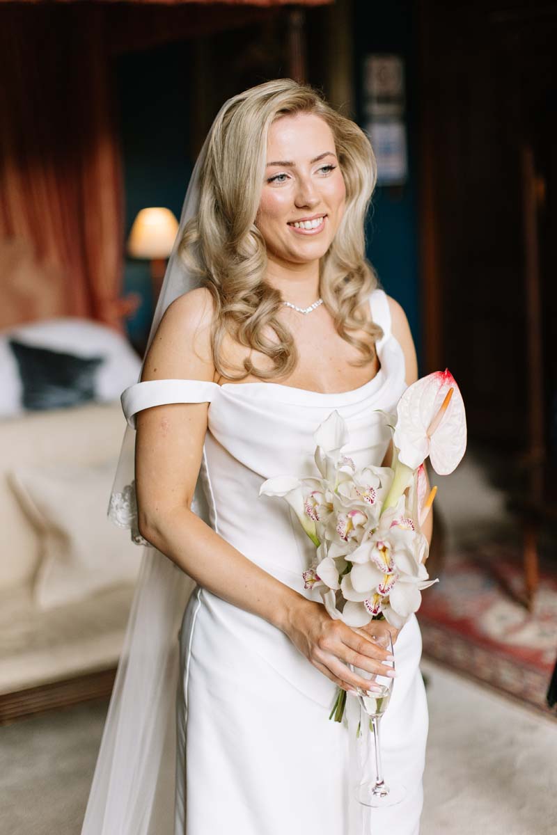 Bride Lia holds a white orchid and anthurium wedding bouquet by The Petal Shoppe at Cambo House.