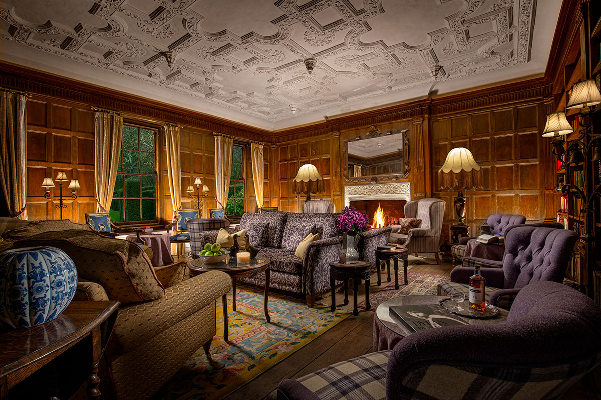 Wood-panelled library at Thackray House with open fireplace, patterned furnishings and traditional décor.