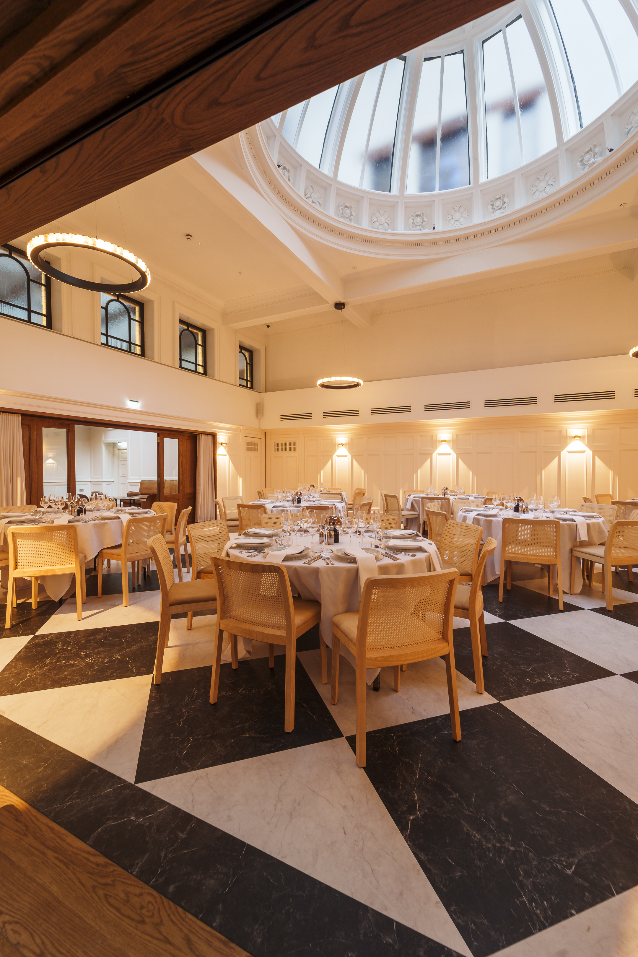 the collector's hall in glasgow set up for wedding dinner with black and white marble flooring and round tables in focus