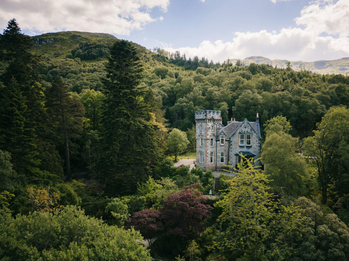 exterior of carrick castle nestled in greenery and trees