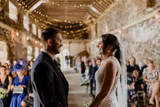 couple at alter inside a barn