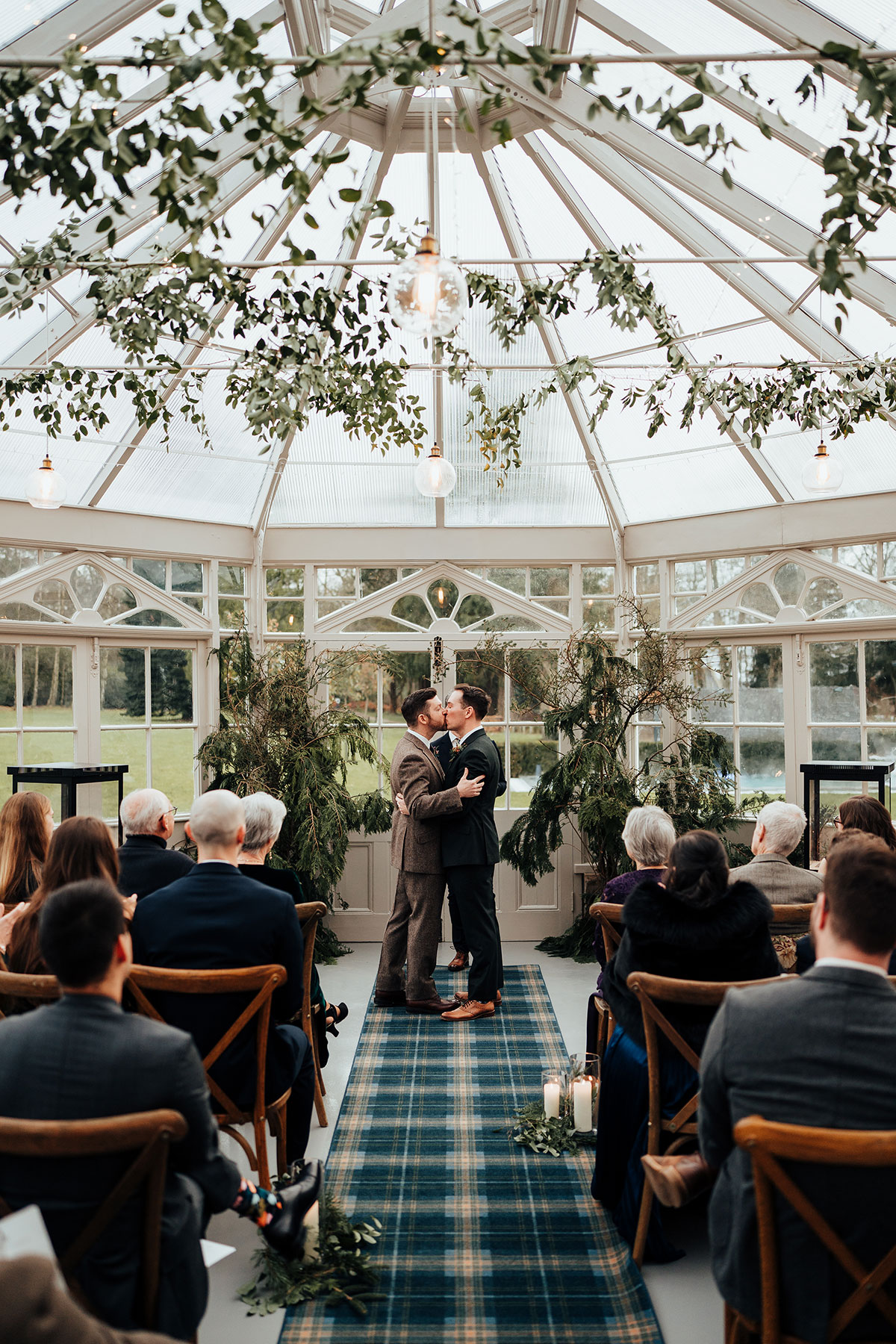 The newlyweds share their first kiss in the glasshouse ceremony space