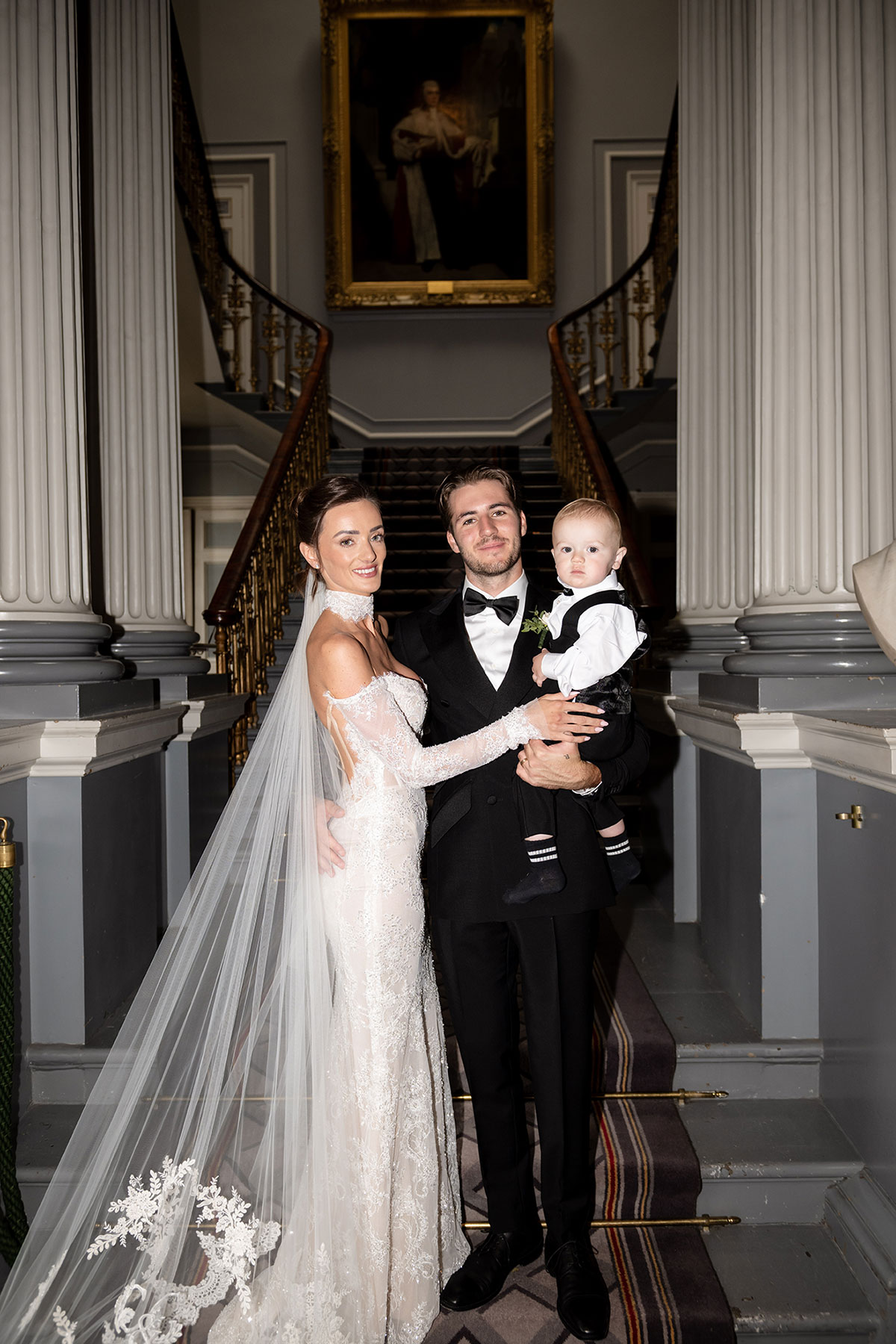 Bride and groom wedding portrait on the staircase at The Signet Library Edinburgh with their child