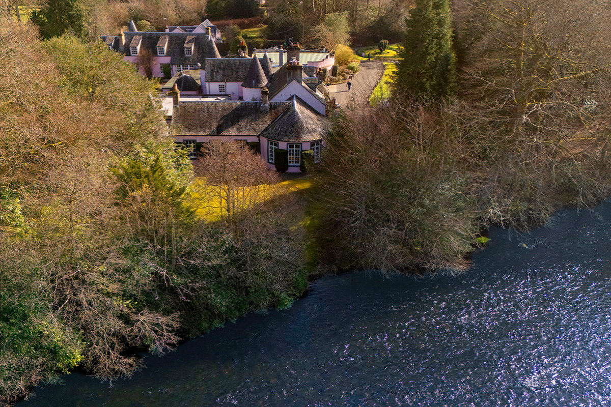 Aerial view of Thackray House in Callander beside the River Teith, surrounded by trees and gardens.
