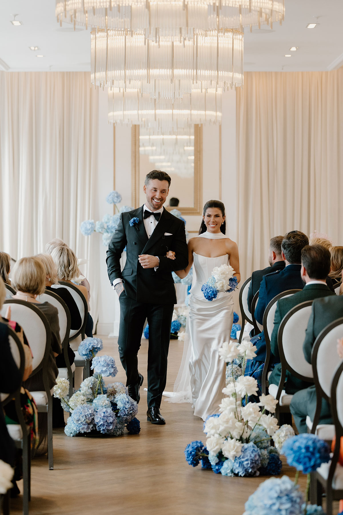 Bride and groom walking back up the aisle after ceremony at The Exchange Glasgow, blue hydrangea aisle flowers