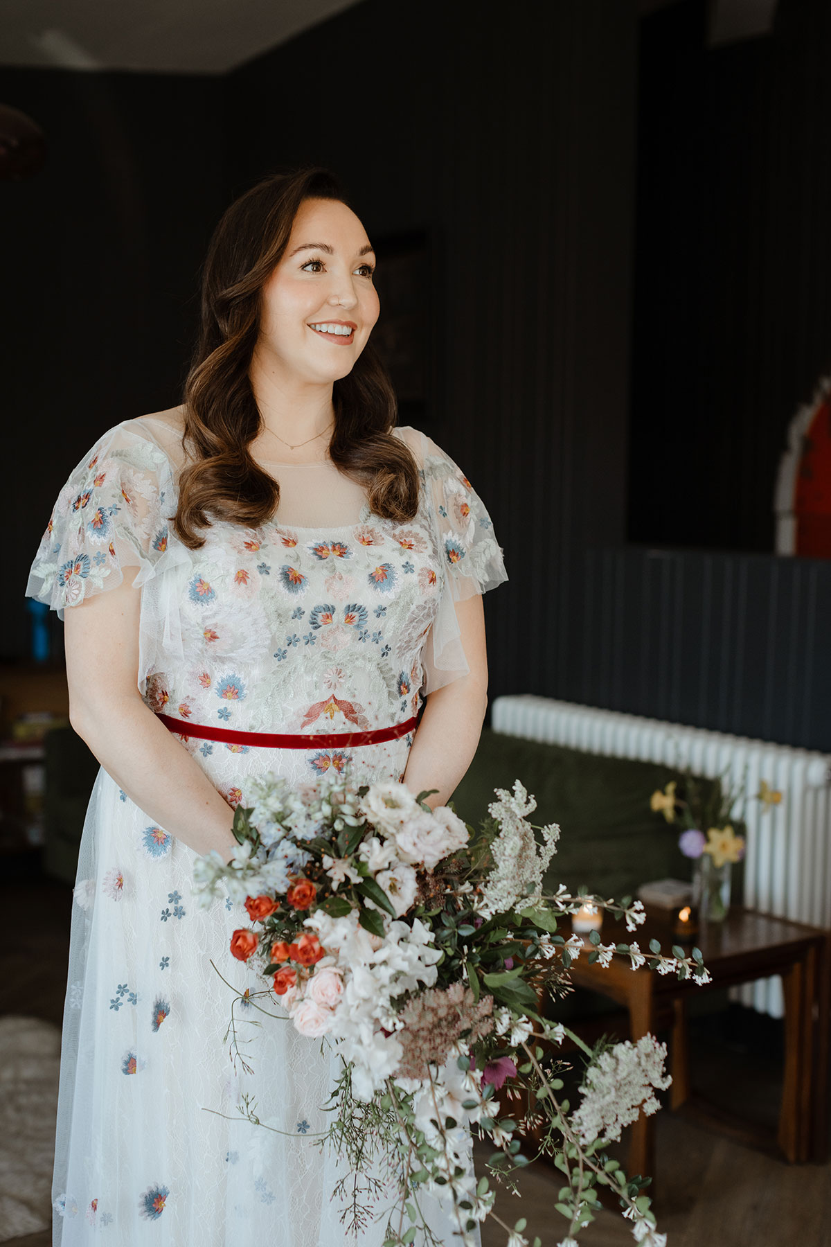 Bride in a white dress with flowers, holding a bouquet 