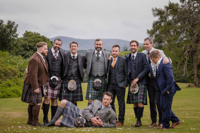 Groom And Male Wedding Guests Posing In Grounds At Raemoir