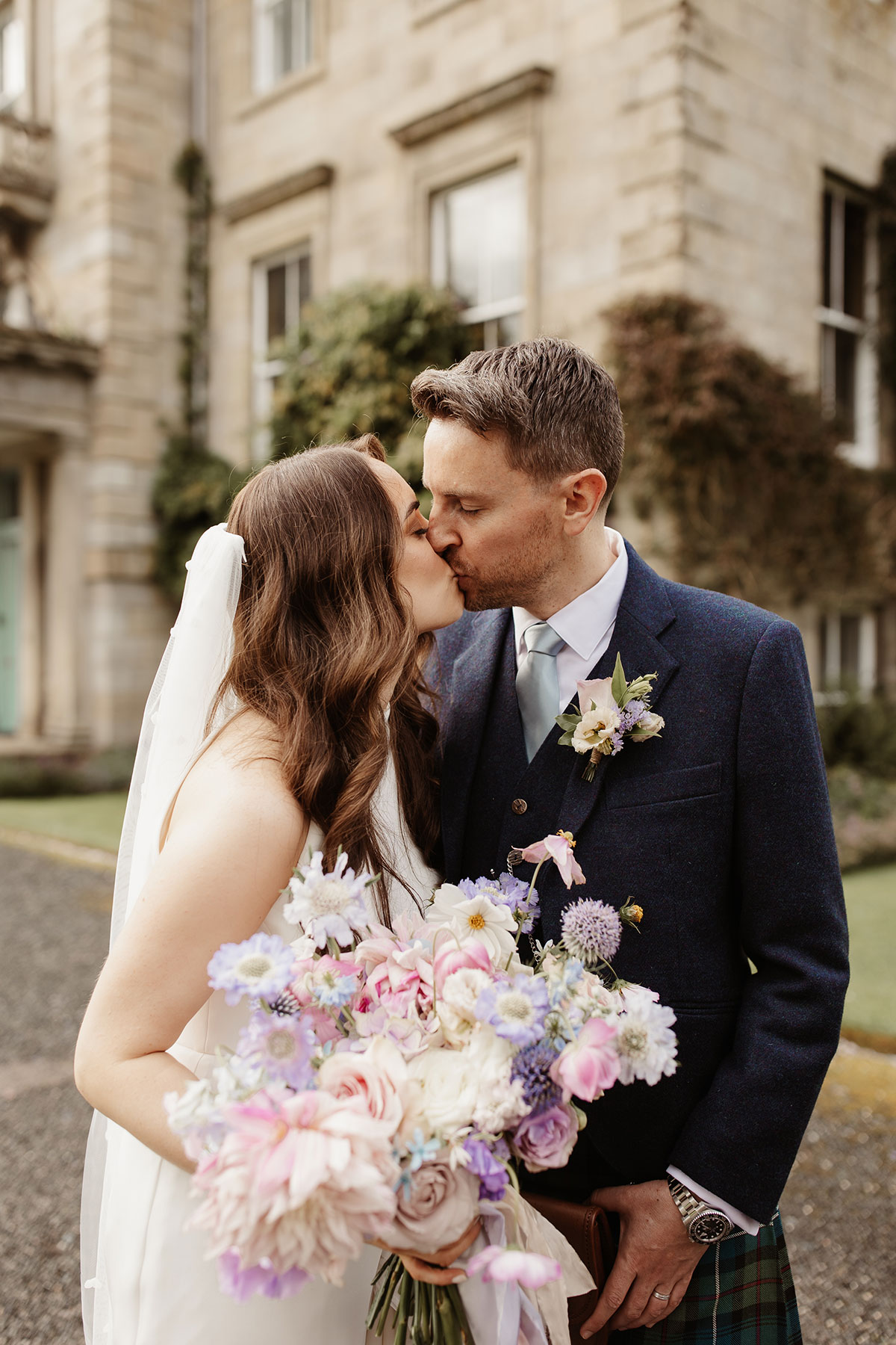 a bride and groom kissing outside Netherdale House