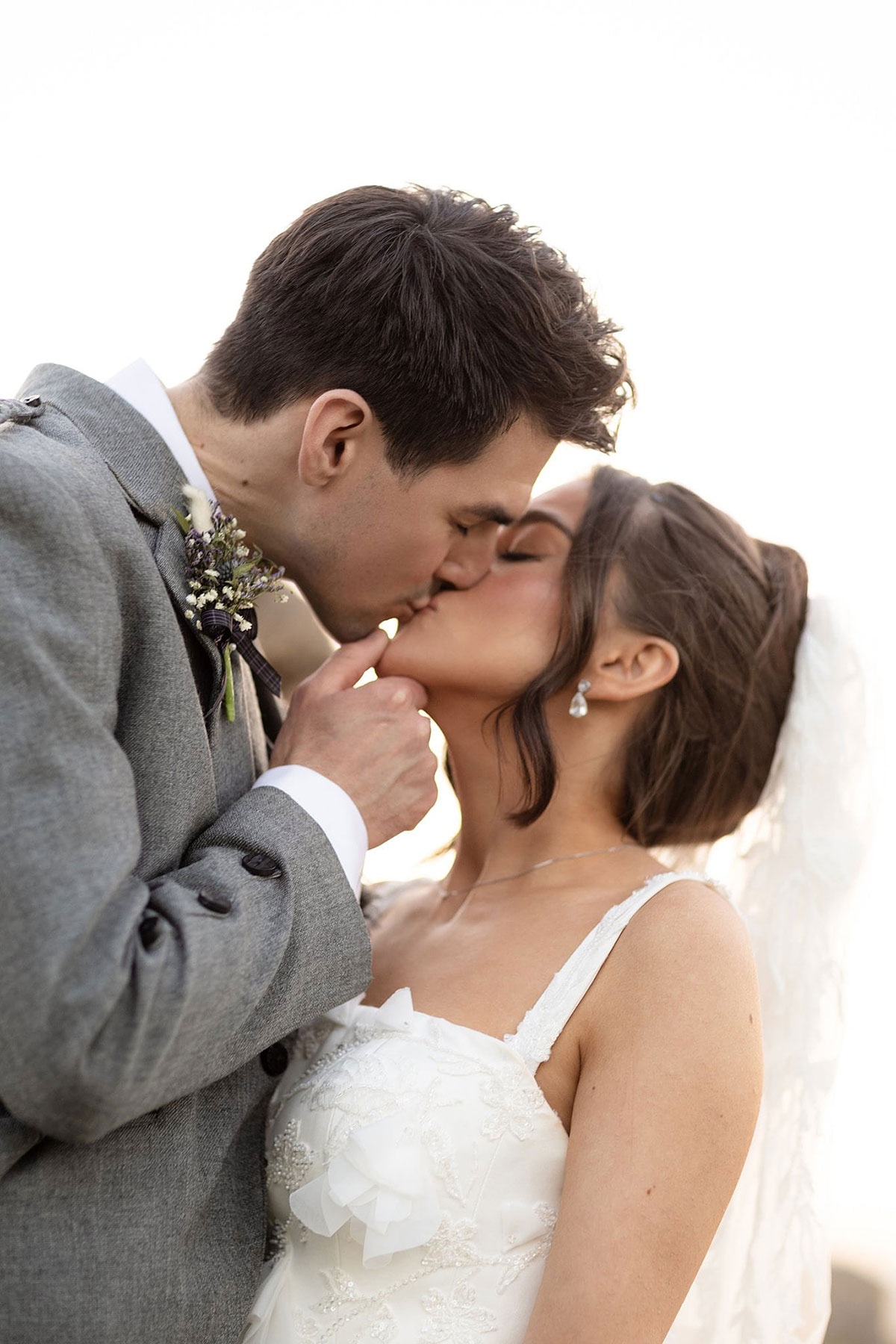 Bride and groom sharing a kiss in golden sunlight during Old Course Hotel St Andrews wedding portraits.