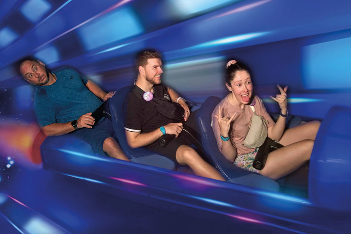 blue rollercoaster ride photo with one woman and two men sat in a row