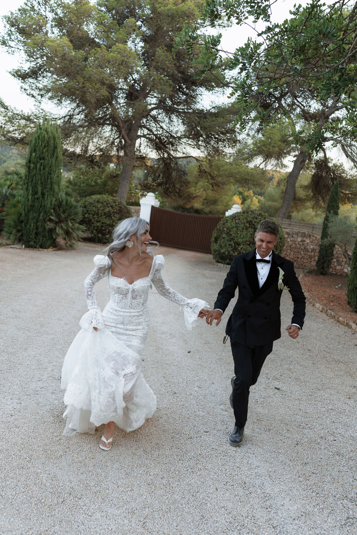 Bride and groom running through the grounds of Can Rafal Ibiza after destination wedding ceremony