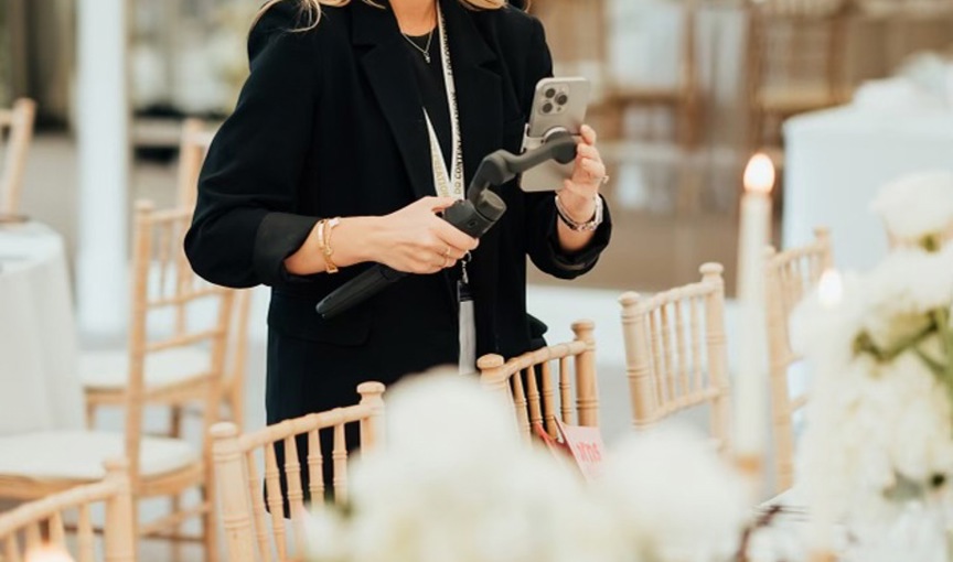 a person filming a table full of white flowers with their phone