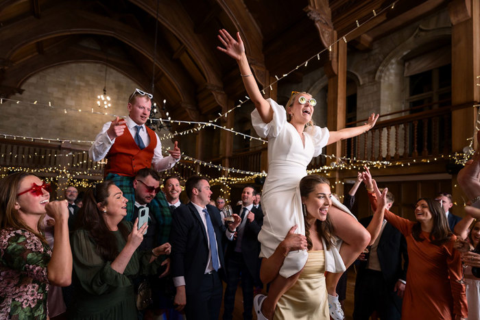 bride and groom on top of guests shoulders during wedding reception at achnagairn castle