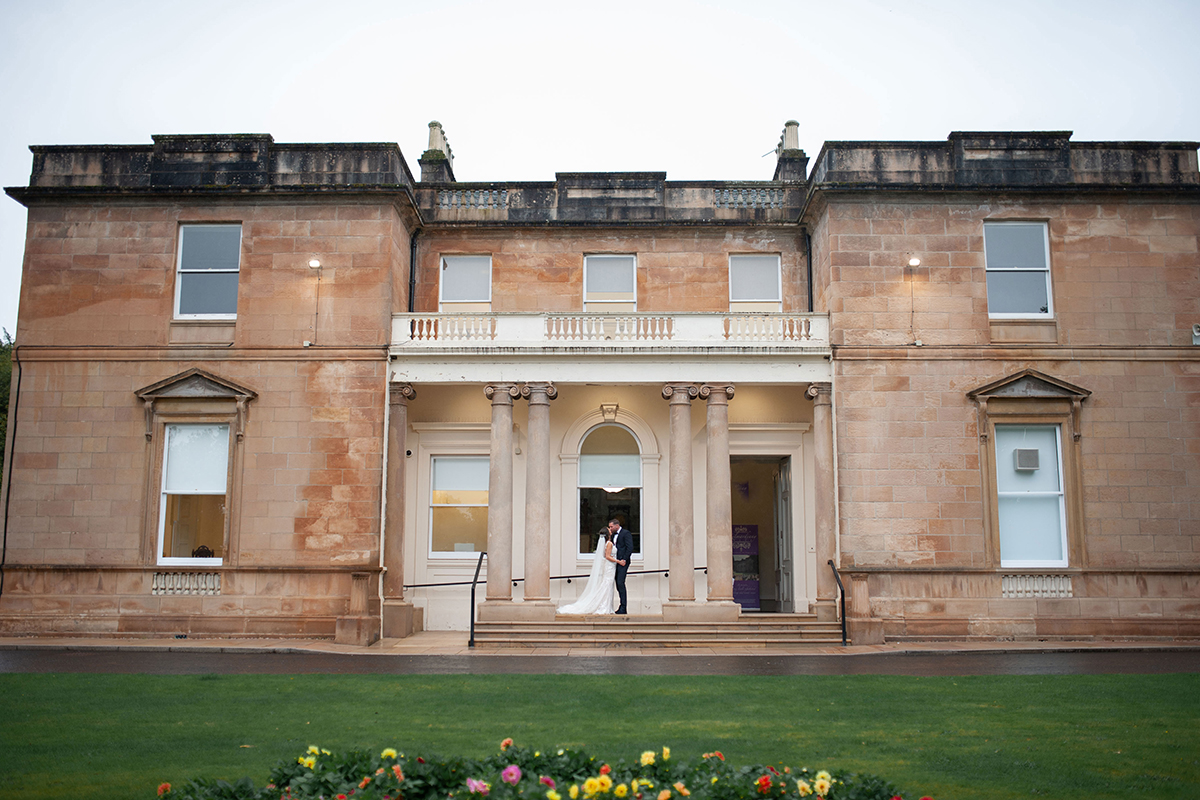 Exterior of Kilmardinny House wedding venue with sandstone façade and front lawn in Glasgow