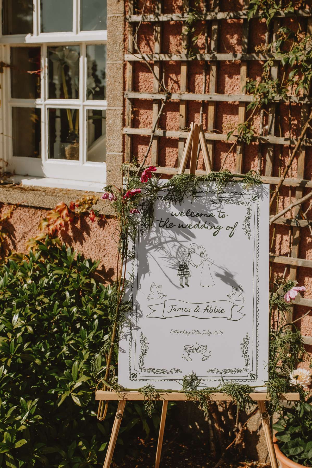 Illustrated James and Abbie wedding welcome sign decorated with flowers outside Ballogie House
