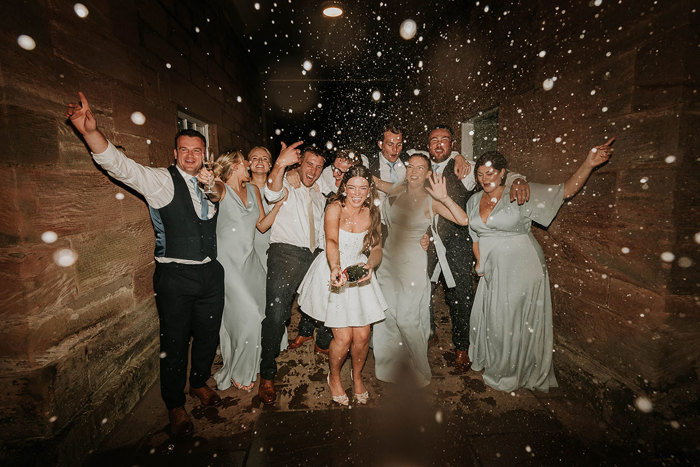 a group of people doing a champagne spray at Dunglass Estate wedding