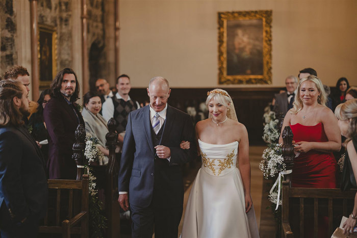 A person in a suit and a bride walking down the aisle.