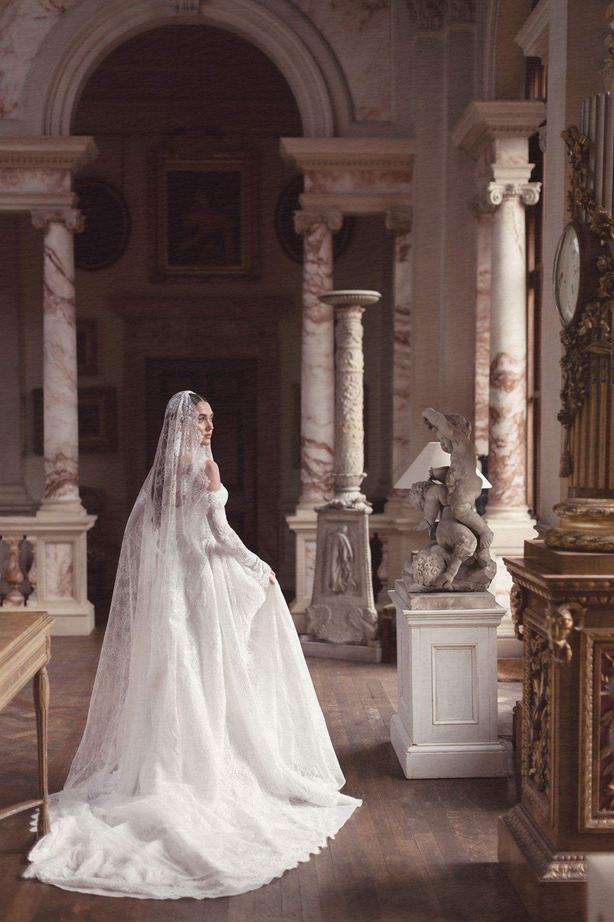 Bridal model in a lace wedding dress and veil inside the marble hall at Gosford House.